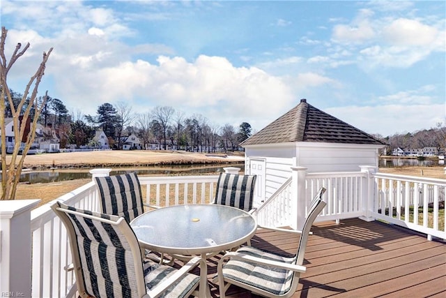 wooden terrace with outdoor dining area and a water view