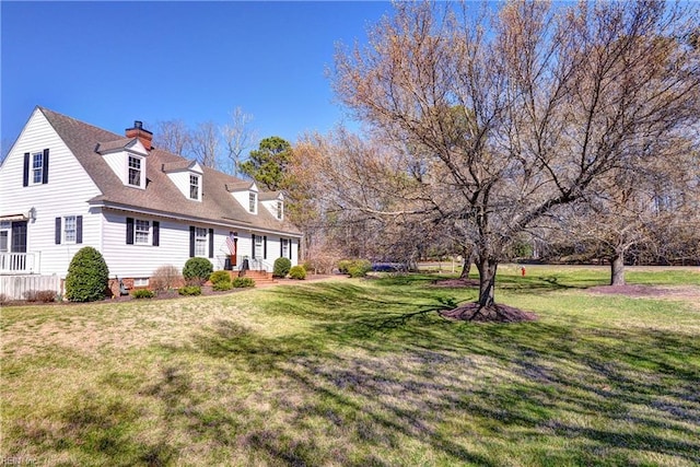 view of front of property featuring a chimney, a front lawn, and a shingled roof