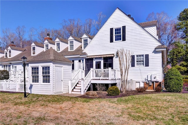 rear view of house with a deck, stairway, a yard, and fence