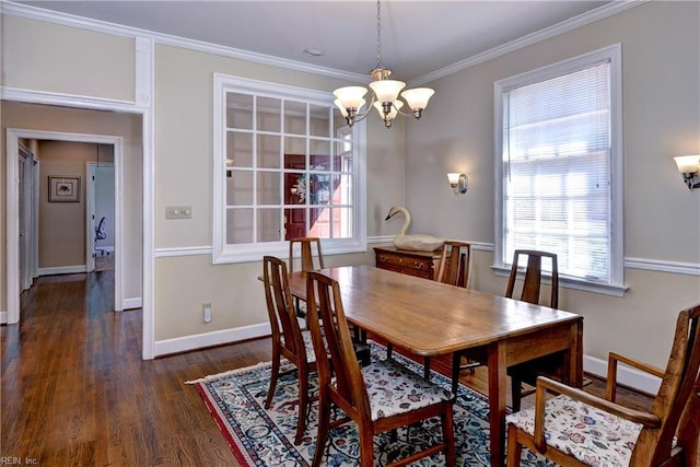 dining area with dark wood finished floors, crown molding, baseboards, and an inviting chandelier