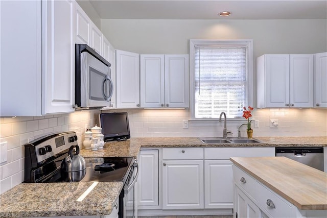 kitchen featuring white cabinets, stainless steel appliances, and a sink