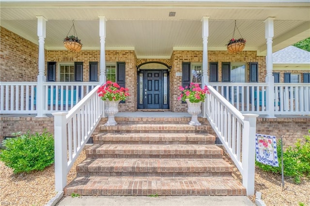 property entrance featuring brick siding and covered porch