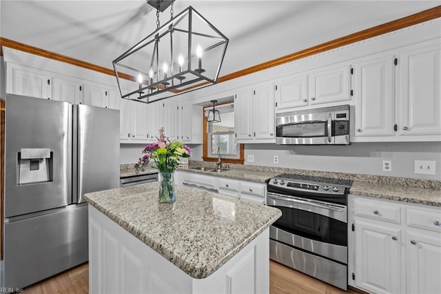 kitchen with white cabinetry, light stone counters, a sink, and stainless steel appliances