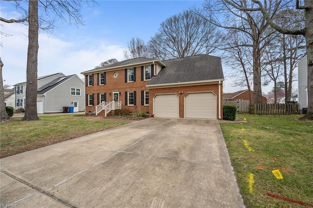 colonial house featuring driveway, a front lawn, fence, an attached garage, and brick siding