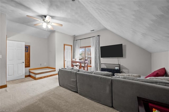 living room with carpet flooring, a ceiling fan, baseboards, and vaulted ceiling