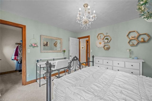 bedroom featuring a walk in closet, an inviting chandelier, light colored carpet, and baseboards