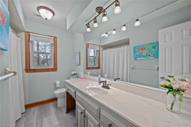 full bath featuring visible vents, baseboards, toilet, wood finished floors, and vanity