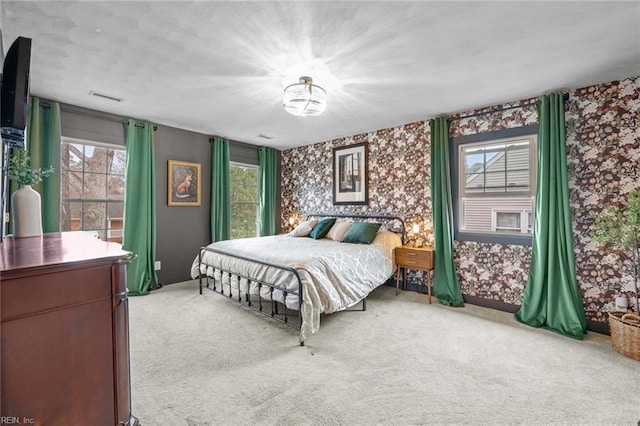 bedroom with visible vents, multiple windows, carpet floors, and wallpapered walls