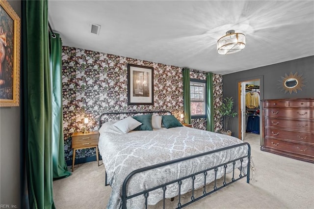 carpeted bedroom featuring a spacious closet, visible vents, wallpapered walls, and a closet