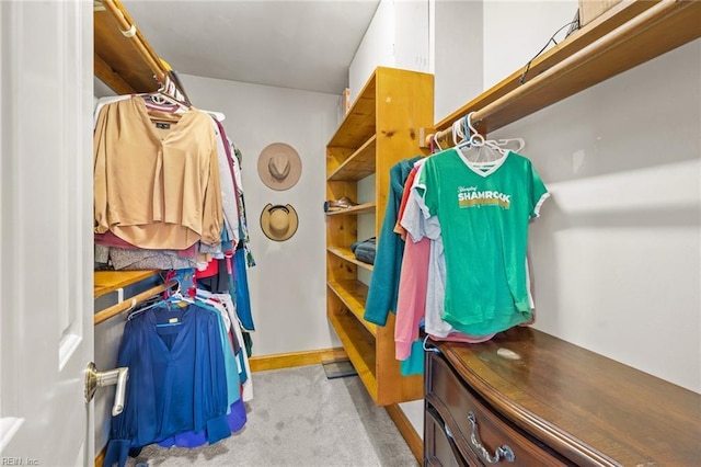 walk in closet featuring light carpet