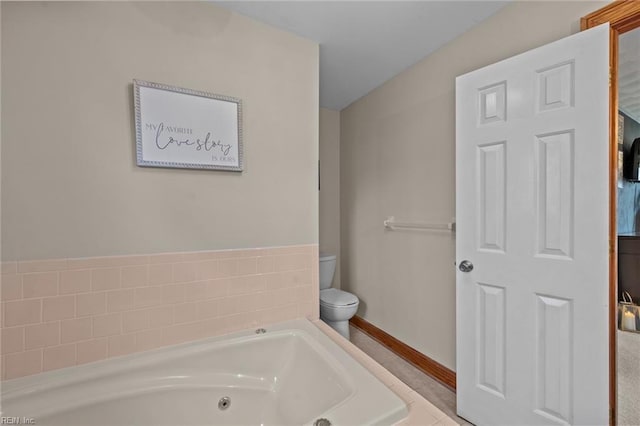 bathroom featuring toilet, baseboards, and a whirlpool tub