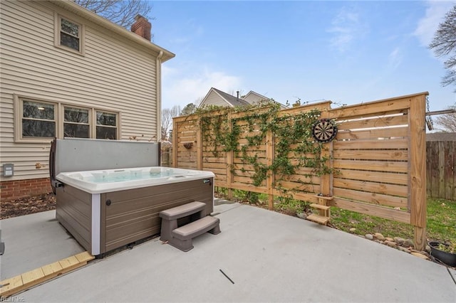 view of patio / terrace with a hot tub and a fenced backyard