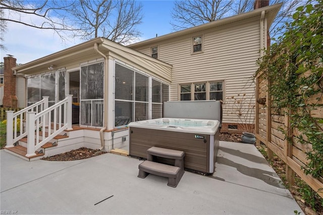 back of property with a hot tub, fence, a sunroom, a chimney, and a patio area