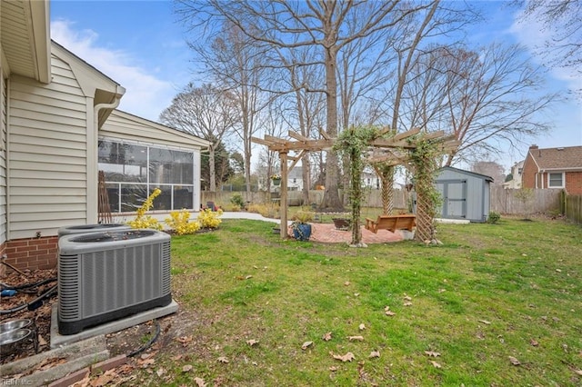 view of yard featuring an outbuilding, central AC unit, a fenced backyard, a sunroom, and a storage shed