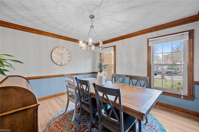 dining room with a wealth of natural light, baseboards, an inviting chandelier, and wood finished floors