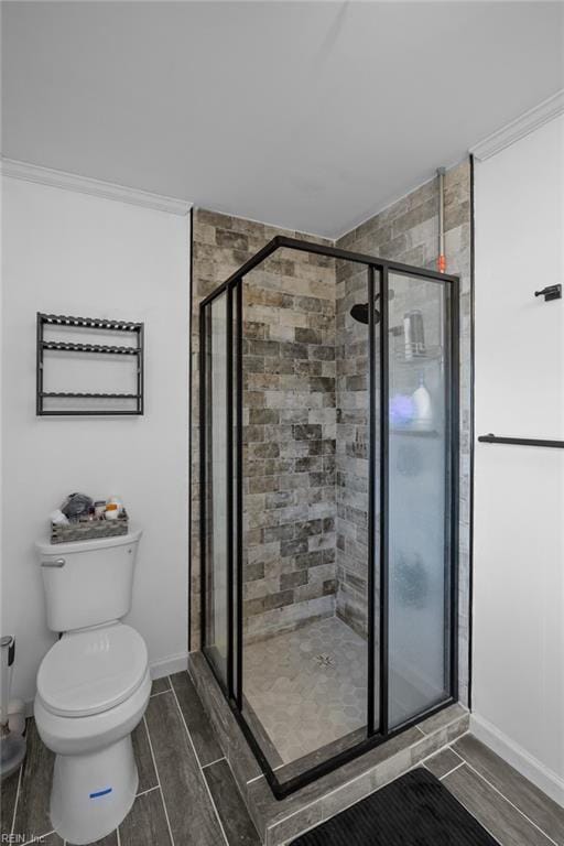 full bath featuring a shower stall, toilet, baseboards, and wood tiled floor