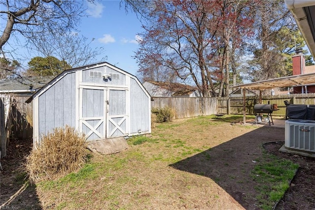 view of yard with a storage unit, a fenced backyard, an outdoor structure, and central AC