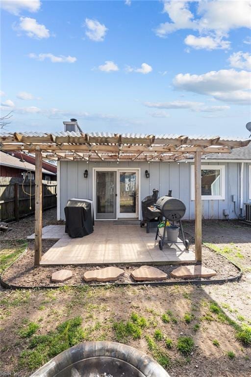 back of house featuring board and batten siding, a patio, fence, and a pergola