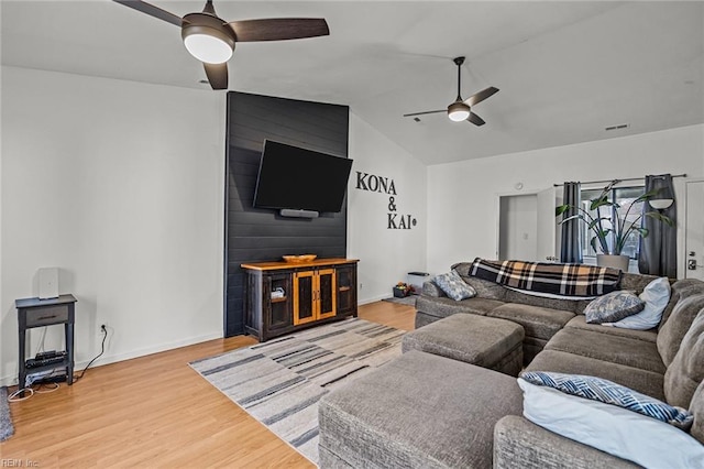 living room with visible vents, baseboards, ceiling fan, lofted ceiling, and light wood-style flooring