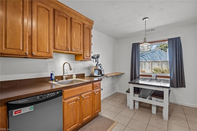 kitchen with dishwashing machine, brown cabinetry, dark countertops, and a sink