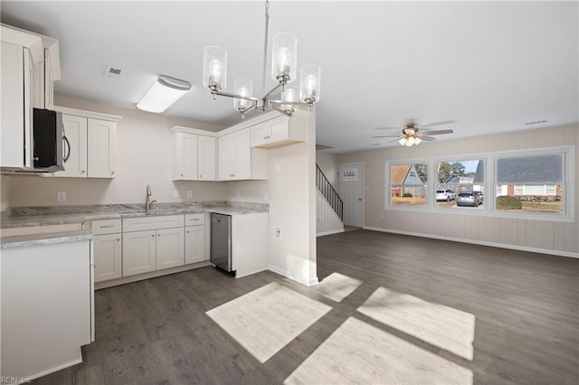 kitchen featuring a sink, stainless steel appliances, dark wood-type flooring, pendant lighting, and white cabinetry