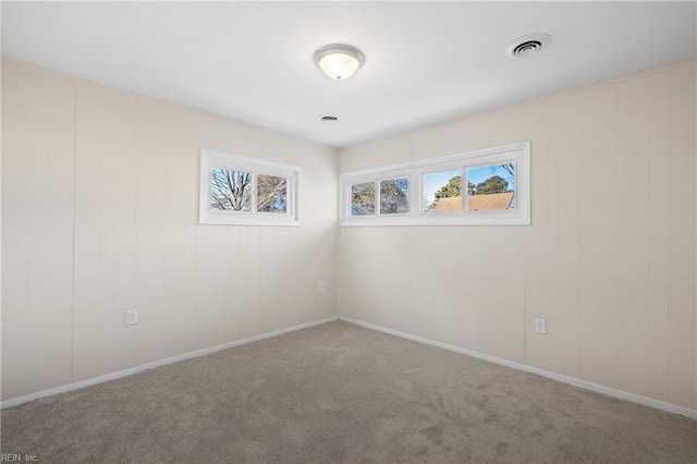 carpeted spare room featuring visible vents and baseboards