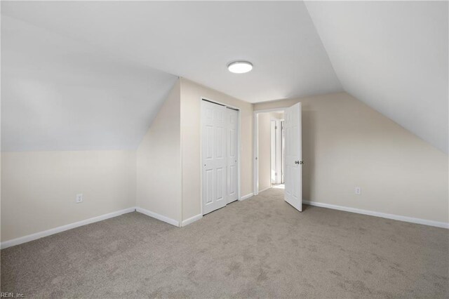 bonus room with baseboards, lofted ceiling, and carpet