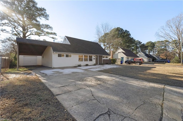 view of front of house with a carport, driveway, a garage, and fence