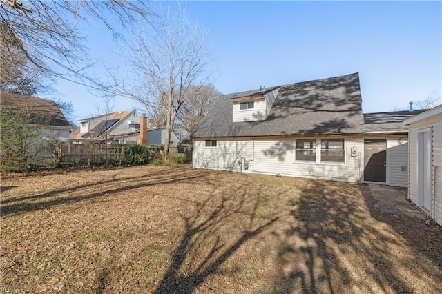 back of house with a lawn and fence