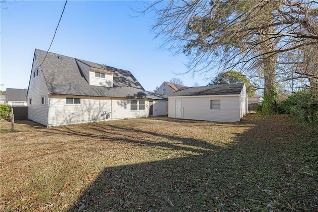 back of property with an outbuilding and a lawn