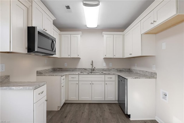 kitchen featuring dark wood-style floors, visible vents, a sink, stainless steel appliances, and white cabinetry