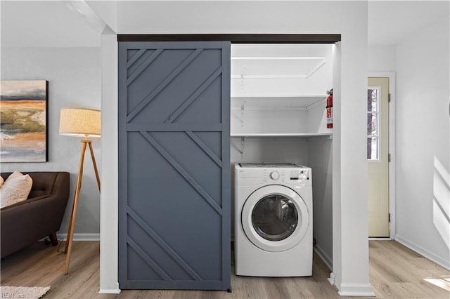 washroom with laundry area, light wood-style flooring, washer / clothes dryer, and baseboards