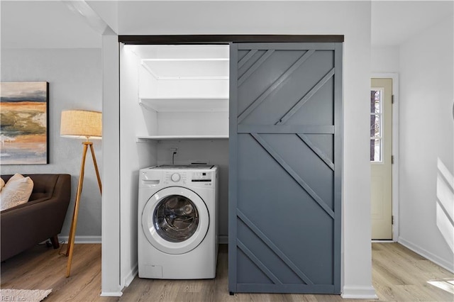 washroom with laundry area, washer / clothes dryer, light wood-type flooring, and baseboards