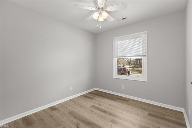 empty room with visible vents, baseboards, wood finished floors, and a ceiling fan