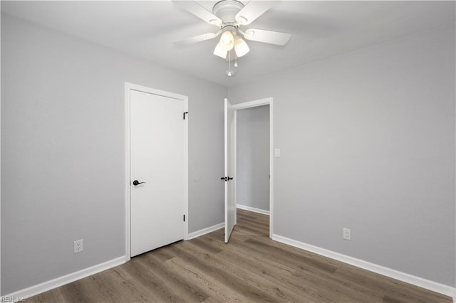 unfurnished bedroom featuring wood finished floors, baseboards, and ceiling fan