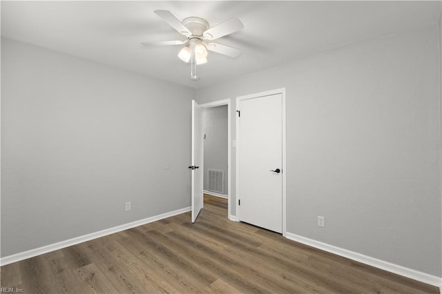 unfurnished room with visible vents, ceiling fan, baseboards, and wood finished floors