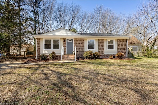 ranch-style house with a front yard, fence, and brick siding