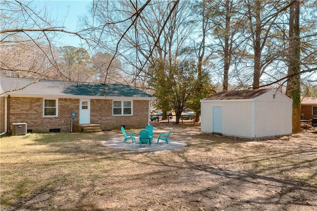 back of property featuring an outbuilding, a shed, cooling unit, crawl space, and brick siding