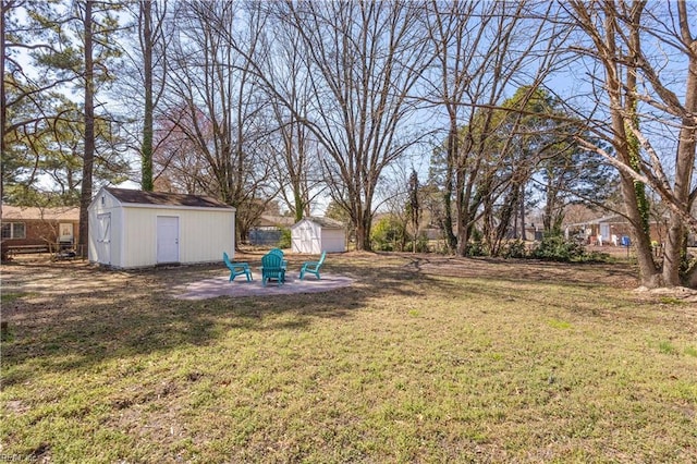 view of yard with a storage shed, a patio area, an outdoor structure, and an outdoor fire pit