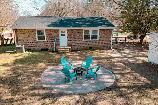 back of house with an outdoor fire pit, fence, crawl space, brick siding, and central AC unit