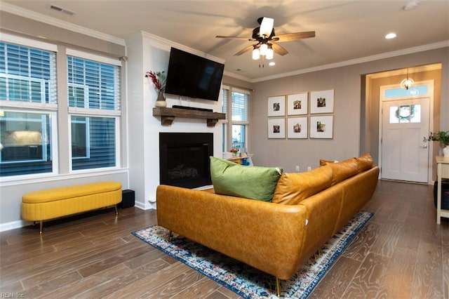 living area featuring a fireplace, wood finished floors, visible vents, and ornamental molding