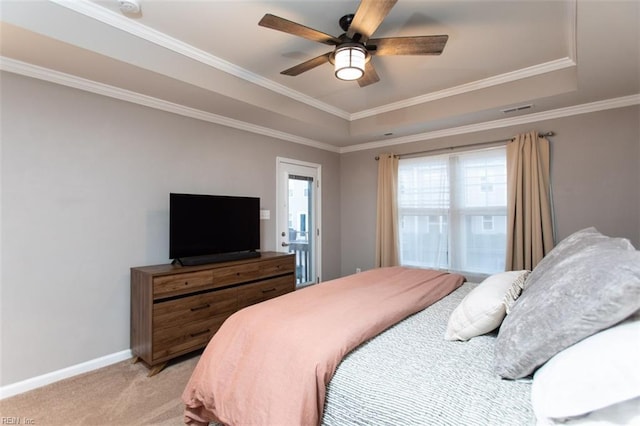 bedroom with a tray ceiling, light carpet, baseboards, and visible vents
