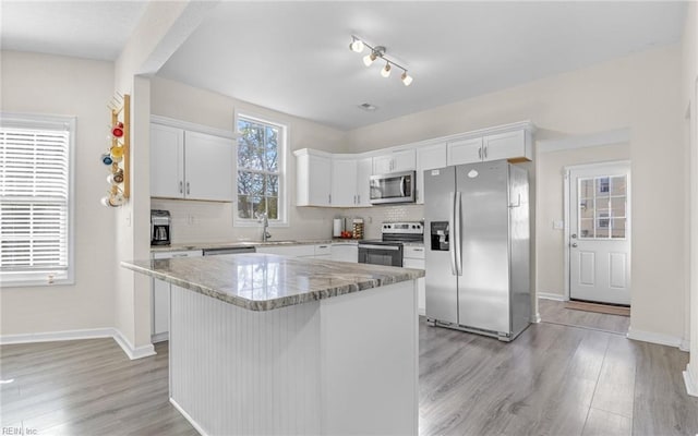 kitchen featuring backsplash, stainless steel appliances, and light wood-style floors