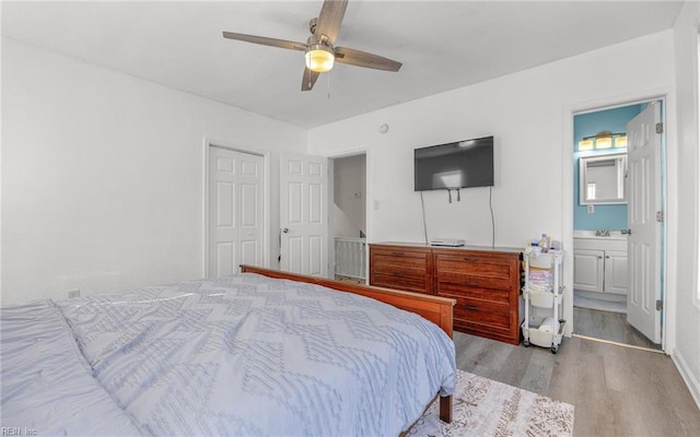 bedroom with ceiling fan, a closet, ensuite bath, and wood finished floors