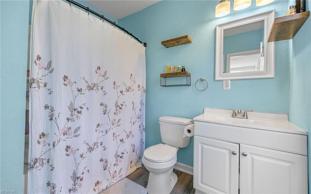 full bathroom featuring vanity, a shower with curtain, wood finished floors, baseboards, and toilet