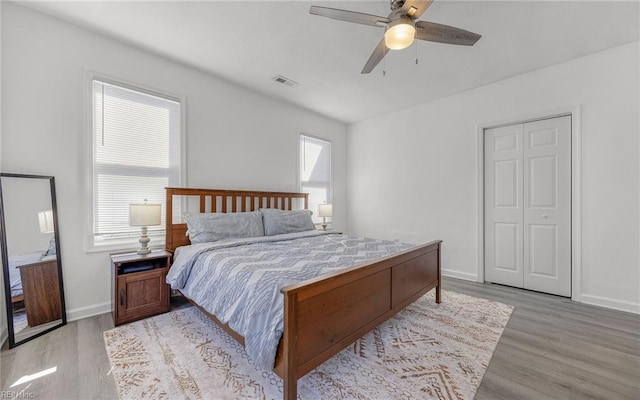 bedroom with visible vents, ceiling fan, light wood-type flooring, and baseboards