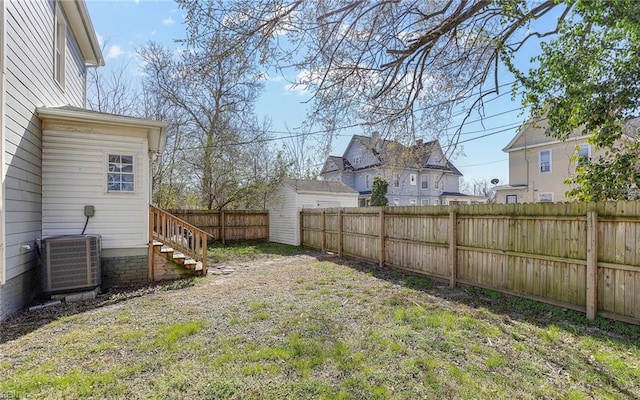 view of yard featuring central AC and a fenced backyard