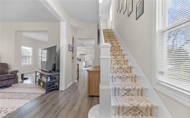 stairway featuring wood finished floors and baseboards