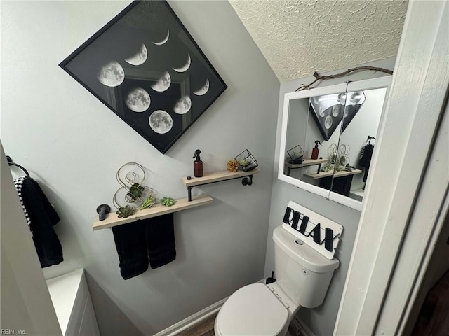 bathroom with toilet and a textured ceiling