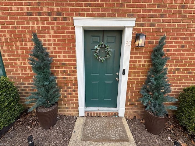 doorway to property featuring brick siding